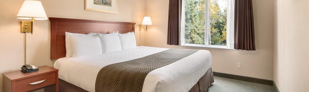 A large king bed at the Days Inn hotel located near the Thunder Bay Health Sciences Centre